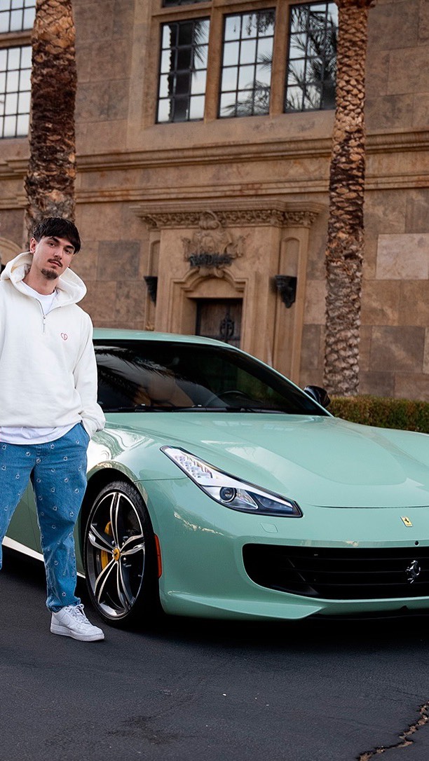 Bryce Hall standing beside a mint green Ferrari GTC4Lusso outside a Las Vegas estate for Lusso Auto Design