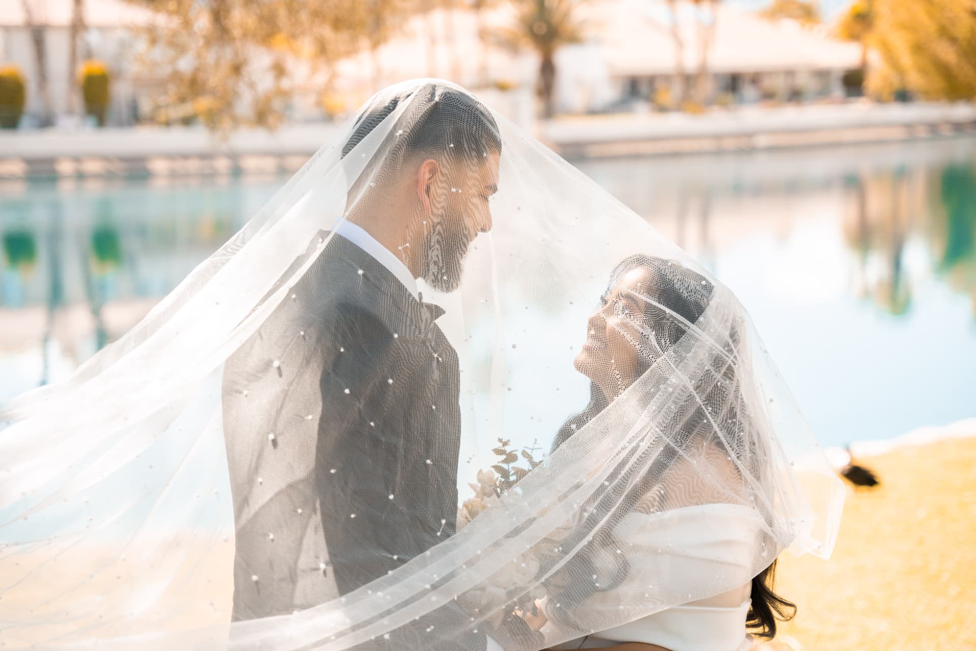 Las Vegas wedding couple under the veil beside the water