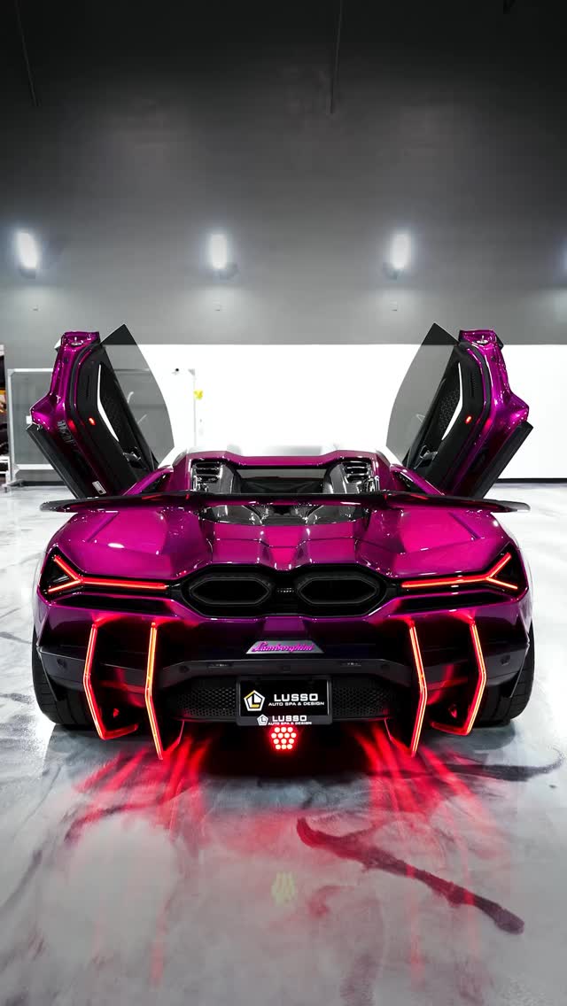 Rear view of a magenta Lamborghini Revuelto with scissor doors open inside the Lusso Auto Spa & Design detail bay in Las Vegas