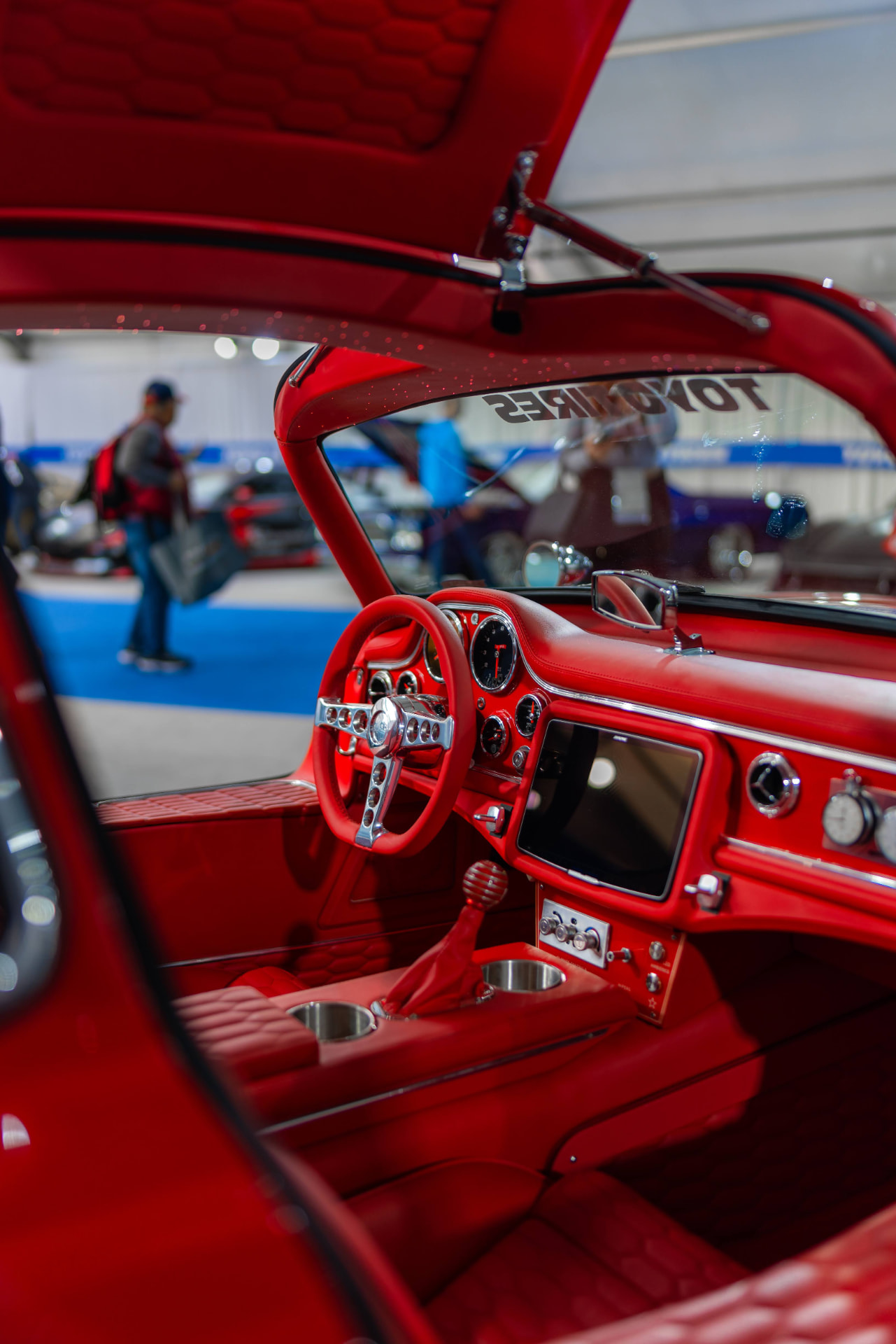 Red custom classic car interior with matching dashboard and shifter at a Las Vegas trade show display