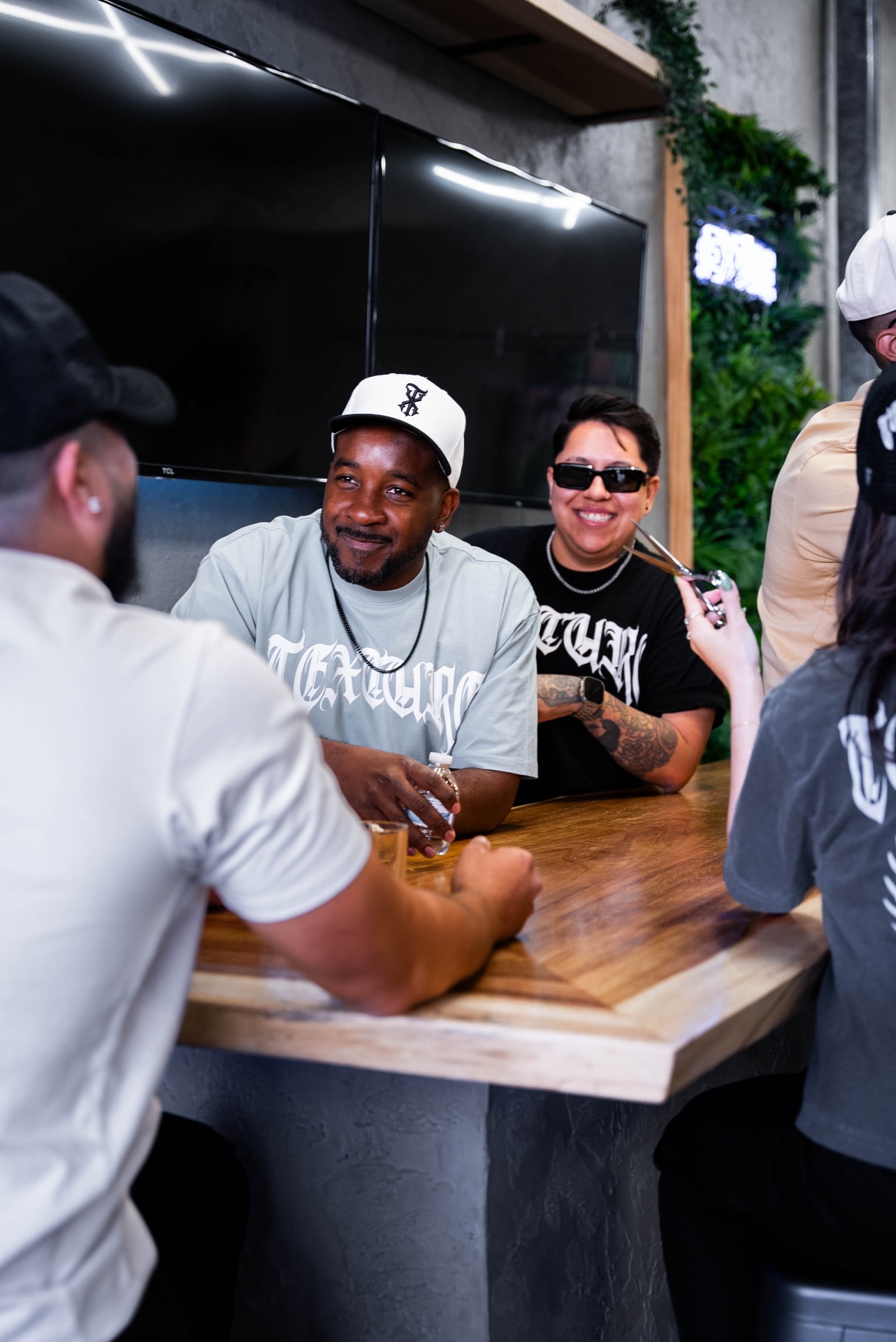 Clients and Texture Barbershop team laughing together at the shop's bar in Las Vegas